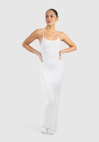 Langes, eng anliegendes Kleid aus weichem, hellgrauem Stoff mit dünnen Trägern. Das Design zeichnet sich durch eine schlichte Silhouette und eine leichte Textur aus.