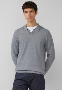 Szary prążkowany dzianinowy sweter z dekoltem w serek i kontrastującym kołnierzem, z długimi rękawami oraz ściągaczami na mankietach i dole. Odpowiedni do noszenia na co dzień.