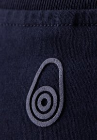 Granatowa tkanina z jasnoszarym logo w kształcie awokado, z koncentrycznymi okręgami, fakturowana dla wizualnego kontrastu z gładkim tłem.