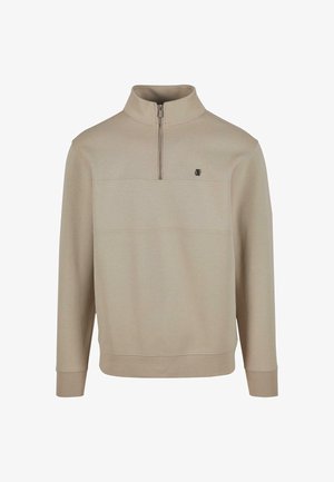 Beige színű pulóver, félig cipzáras gallérral, hosszú ujjal és elöl varrás részlettel. Kicsi logóval a mellrészen. Puha szövetanyag.