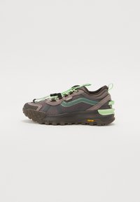 Vans sneaker featuring a brown and green mesh upper, contrasting laces, a textured rubber sole, and a Vibram accent on the heel.