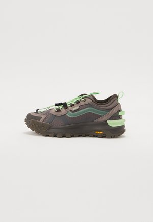 Vans sneaker med en brun og grøn mesh-overdel, kontrasterende snørebånd, en tekstureret gummisål og en Vibram-detalje på hælen.