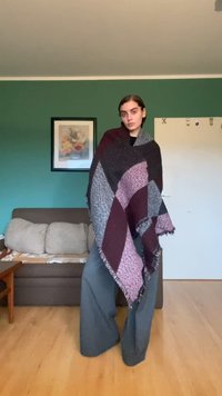 Multifarvet oversized sjal med geometriske mønstre i mørk burgunder, grå og lys lilla, afsluttet med frynser.