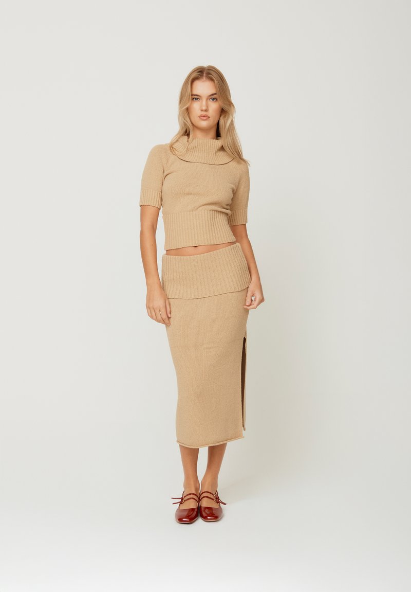 Strikket to-dels sett i beige som har en cropped, teksturert topp med høy krage og et matchende midi-skjørt med en side-split.
