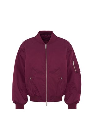 Veste bomber bordeaux avec fermeture éclair frontale, col, poignets et bas en côtes, deux poches à pressions et une poche zippée sur la manche gauche.