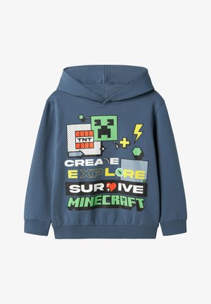 Sweat à capuche bleu avec un graphique frontal présentant des icônes sur le thème de Minecraft, incluant un creeper, de la TNT et des phrases telles que « CRÉER », « EXPLORER », « SURVIVRE ».