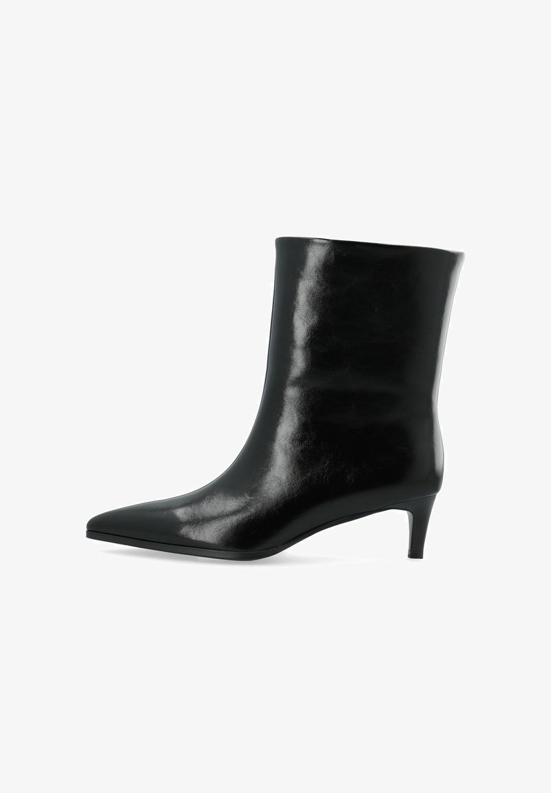 Bottine en cuir noir avec bout pointu et talon court et fin sur fond blanc.