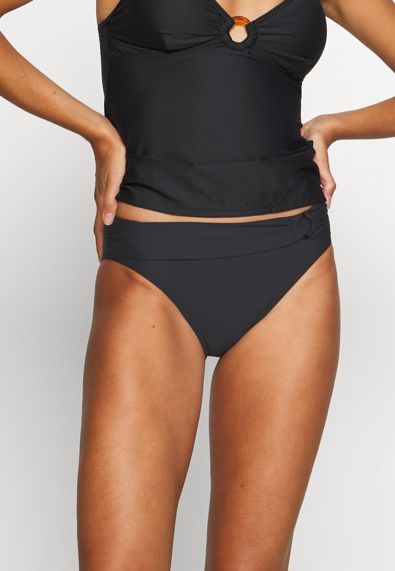 Juodas bikini viršus su apvaliu akcentu centre, derinamas su aukštu juosmeniu juodais bikini apatiniais, turinčiais šoninį susiraukšlėjimą.
