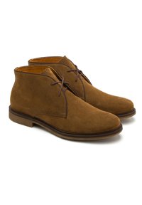 Brązowe zamszowe botki na kostkę o gładkiej strukturze, zaokrąglonym nosku i minimalnym wiązaniu. Posiadają gumową podeszwę oraz kontrastowe wykończenie wnętrza.