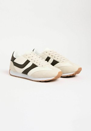 Skrienēšana ar bēšu zamšādas un sieta augšdaļu, tumši zaļām akcentu svītrām, baltām vidējām zolēm un brūnu gumijas ārējo zoli.