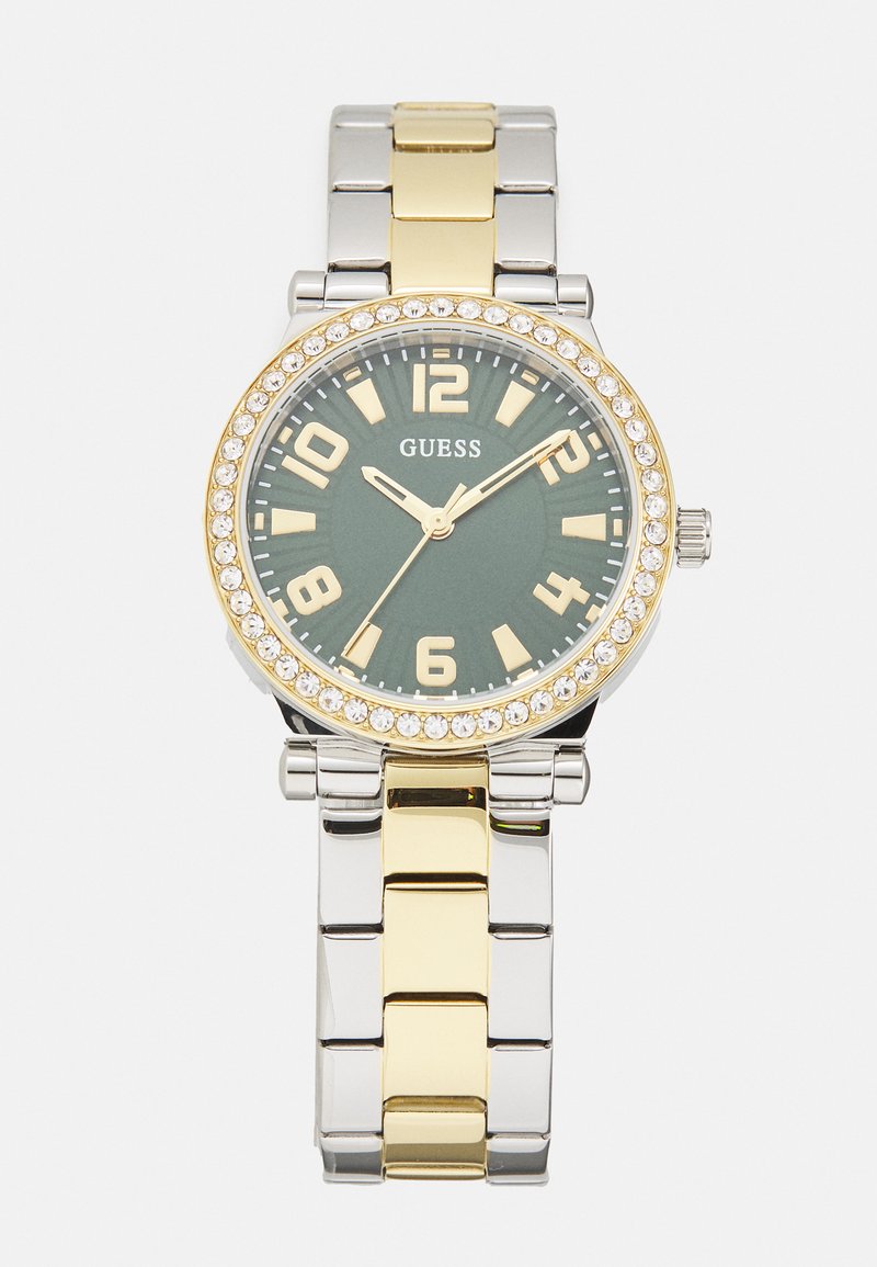 Ezüst és arany színű fém óra zöld számlappal, nagy arany számokkal és kristályokkal díszített kerettel. Linkes karkötős kialakítással bír.