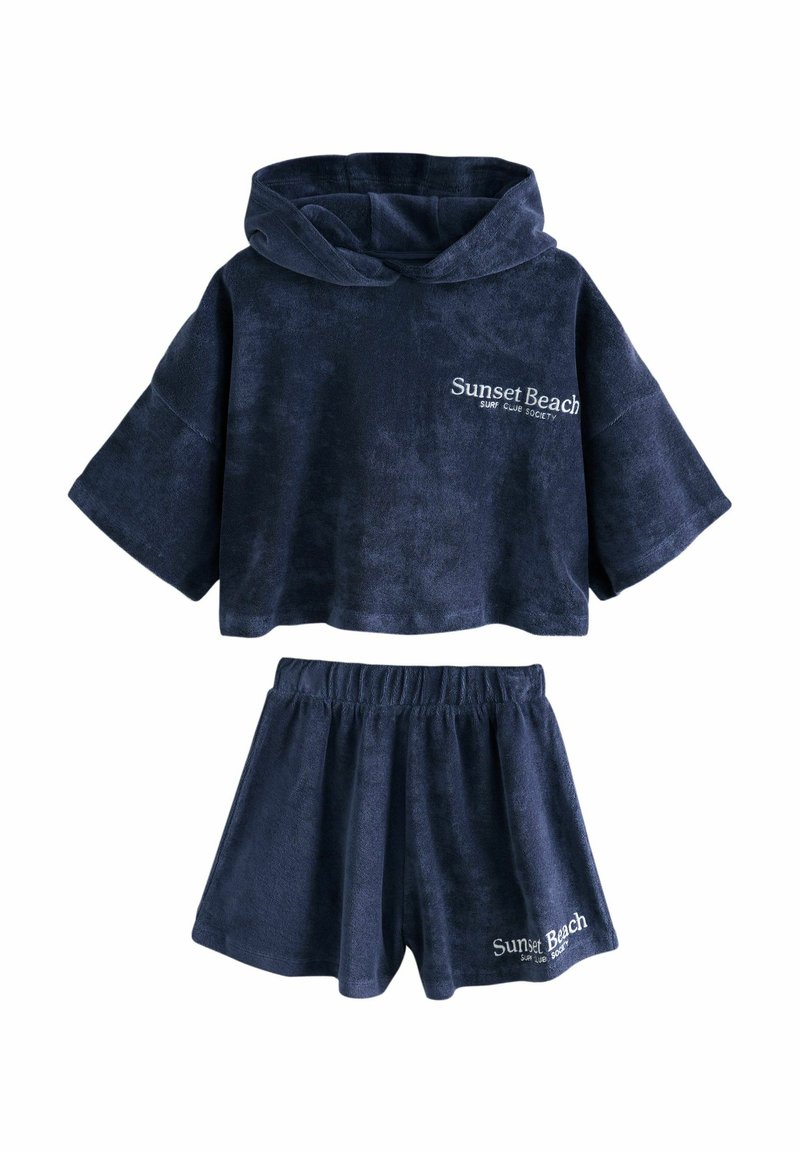 Navy-blaues Velour-Zweiteiler-Outfit, bestehend aus einem cropped Hoodie mit einer Fronttasche und passenden Shorts mit elastischem Bund und Logo.