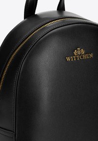 Černý batoh z umělé kůže zaobleného tvaru, s zlatým zipem a embosovaným logem "WITTCHEN" na přední straně. Hladký povrch, minimalistický design.