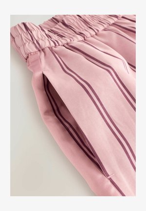 Rosa tygbyxor med en rynkad elastisk midja, som har vertikala mörklila ränder och sida sprund för extra detalj.