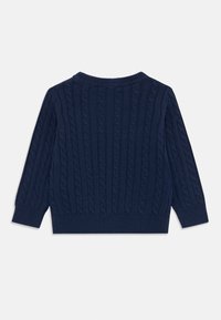 Navy blue cable-knit sweater featuring ribbed cuffs and hem, long sleeves, and a round neckline. Texture is soft and woven.