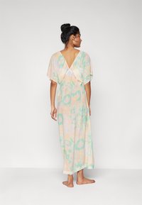 Vestido maxi con espalda en V, que presenta un patrón de tie-dye en tonos pastel de rosa y verde. Fabricado en tejido ligero y con un diseño de mangas holgadas.