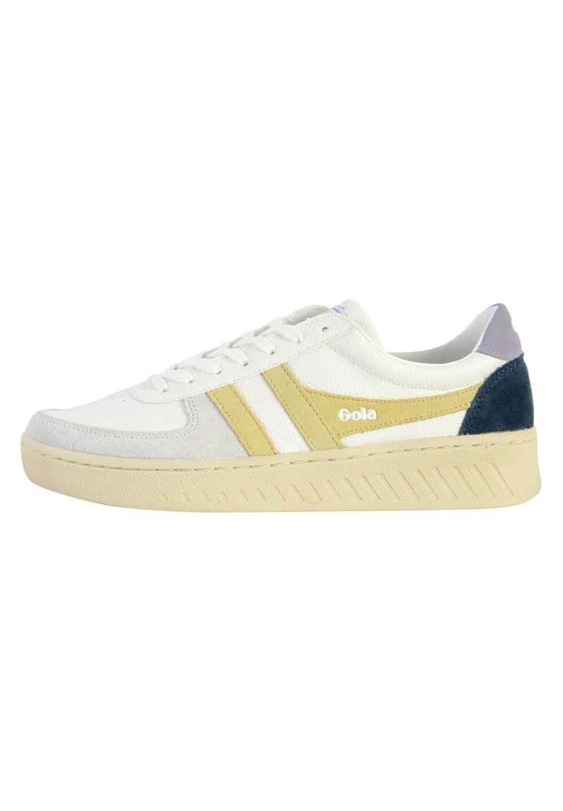 Vit sneaker med gula och grå accenter, material av mocka och läder, tjock krämfärgad sula, texturerade sidostrikar och en logo på sidan.