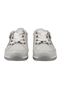 White sneakers with a textured upper, featuring laces, a side zipper, and silver accents. The sole is gray with a rounded shape.