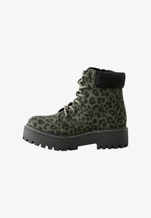 Kampfstiefel mit grünem Leopardenmuster, einem samtigen schwarzen Kragen, einer stabilen schwarzen Plateausohle und metallischen Ösen für die Schnürsenkel.