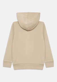 Sudadera beige con capucha, de textura suave, mangas largas y puños y bajo acanalados. La parte trasera presenta una costura central en la capucha.