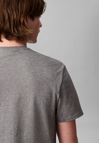 Γκρι κοντομάνικο T-shirt με στρογγυλή λαιμόκοψη, που διαθέτει λεία, απαλή υφή και άνετη εφαρμογή. Το ύφασμα φαίνεται ελαφρύ και διαπνέον.