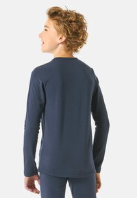 Navy long-sleeve T-shirt made of soft fabric with a round neckline, fitted design, and seamless construction emphasizing comfort and ease of movement.