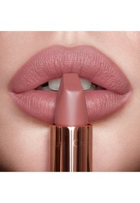 Matt nude Lippenstift in einer quadratischen Hülse. Der Lippenstift hat eine glänzende roségoldene Hülle und ist auf weichen, glatten, rosafarbene Lippen aufgetragen.