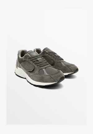Gray suede and mesh sneakers feature a padded tongue and collar, flat laces, and a white textured midsole with black rubber outsole.