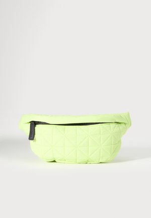 Sac banane en tissu matelassé vert clair avec fermeture éclair noire et tirette, présenté sur un fond neutre.