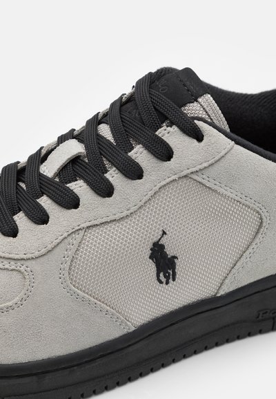 Gray suede sneaker with black mesh accents, black laces, and a rubber sole. Features embroidered logo on the side.
