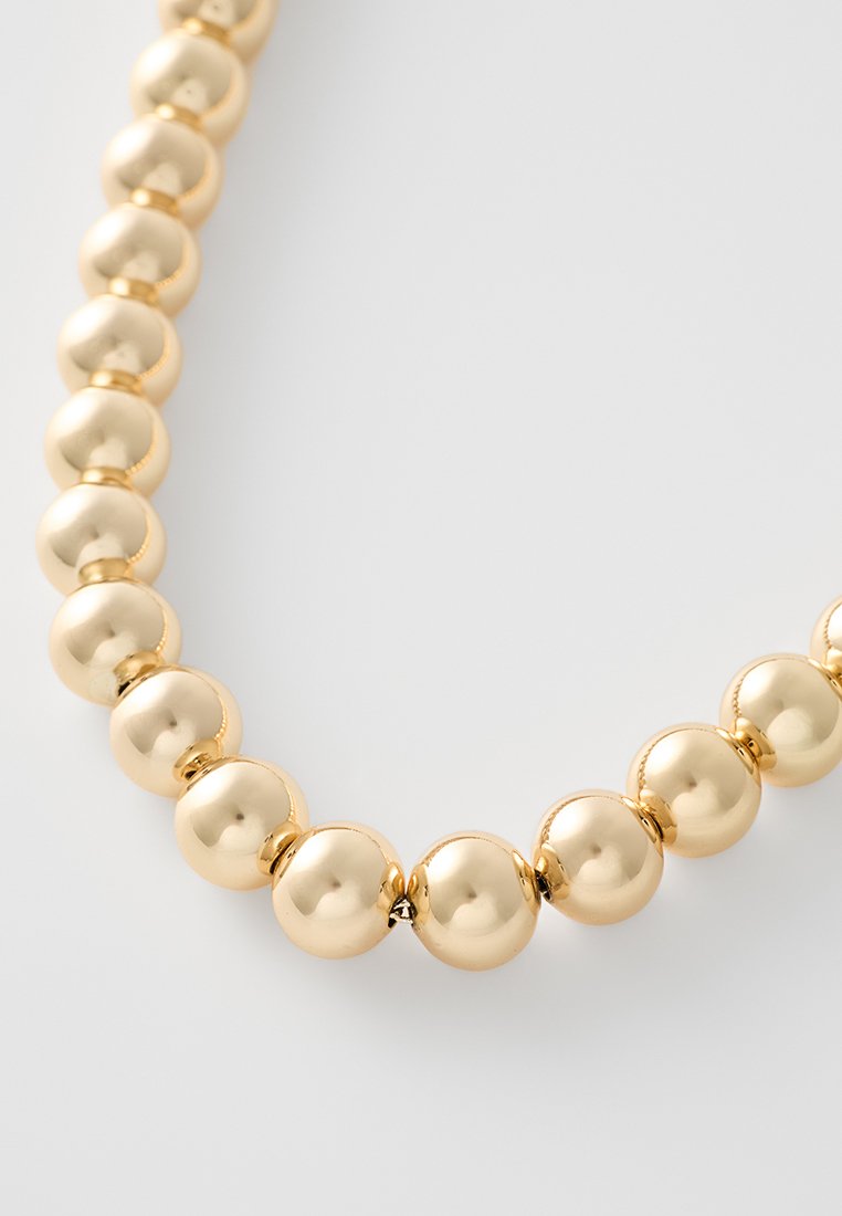 Collana di perle dorate con sfere lisce e lucide, raccolte in modo ravvicinato per un aspetto elegante.
