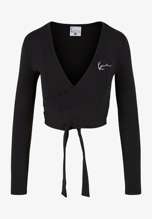 Črni dolg rokav zapenjajoči zgornji del iz mehkega blaga, s globokim V-izrezom, s povezanjem na pasu in majhnim belim logotipom na prsih.