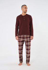 Marlboro långärmad skjorta i vinröd med treknapprad, kombinerad med rutiga pyjamasbyxor i vinröd, krämfärgad och brun nyans.