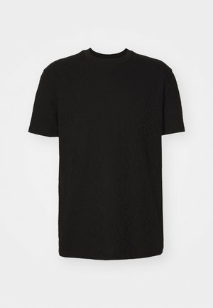 T-shirt noir à manches courtes avec un motif texturé, col rond et coupe régulière. Le tissu semble doux et léger.