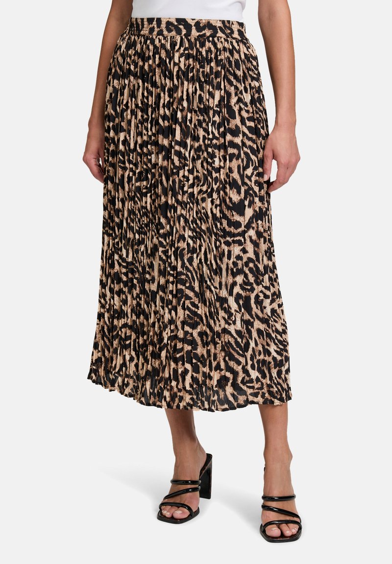 Gelaagde midi-rok in luipaardprint, met een zwart en beige kleurenschema, elastische tailleband en vloeiende stoftextuur. Gecombineerd met spitzenhakken.