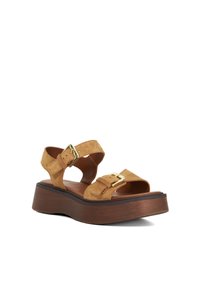 Suède platform sandalen in lichtbruin met twee verstelbare banden en gouden gespen, met een chunky bruine houten zool.