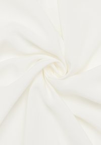 Weißer Stoff mit glatter Textur, sanft zu einer Spirale gedreht, zeigt eine einheitliche Farbe ohne Muster oder Akzente.