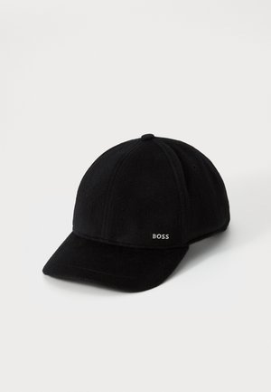 Gorra de béisbol negra con visera curvada y pequeño logo blanco de "BOSS" en el panel lateral frontal, mostrada sobre un fondo blanco liso.