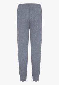 Grå joggebukser med en myk tekstur, med elastisk liv og avsmalnede ankler, vist fra bakvinkelen.