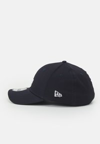 Boné de basebol azul-marinho com aba curva, logotipobordado na frente e ilhós para ventilação. Feito de tecido com detalhes em costura.
