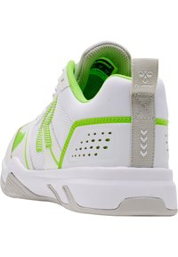 Scarpa sportiva bianca con dettagli in verde neon, parte superiore in mesh, tallone testurizzato e dettagli perforati. Presenta una suola in gomma solida e un'etichetta con il logo.