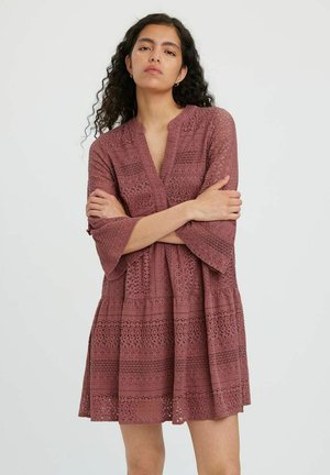 Robe en dentelle bordeaux avec un décolleté en V, des manches cloche trois-quarts et des motifs découpés complexes, dotée d'une jupe évasée.