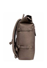 Vattentät brun ryggsäck med rulltoppsstängning, sidopanel i nät och justerbara remmar. Slät textur och minimalistisk design.