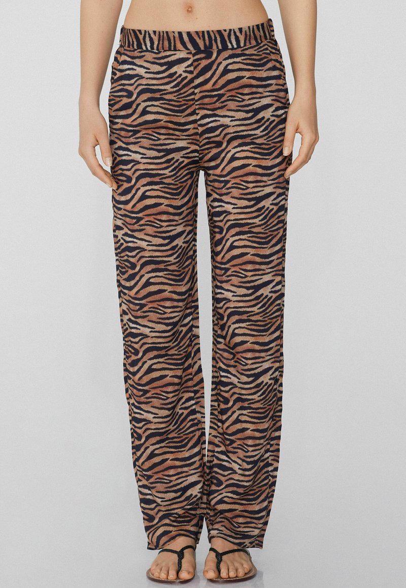 Pantalons amples en tissu doux, avec un motif rayé de tigre dans des tons de marron, noir et beige, dotés d'une taille élastique.