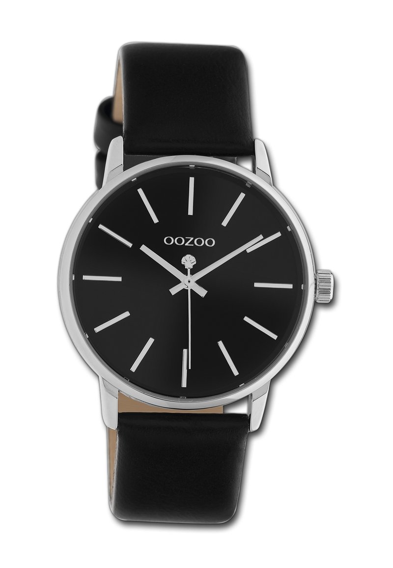 Montre noire avec index argentés, design minimaliste, boîtier rond et bracelet en cuir noir. Présente un cadran simple et une couronne.