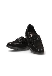 Mocasines negros hechos de ante con un brillante ribete de charol. Presentan una hebilla metálica decorativa y una suela de goma texturizada para mayor agarre.