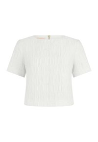 Blouse blanche texturée à manches courtes avec encolure ronde et fermeture éclair dorée au dos, présentée sur un fond blanc uni.