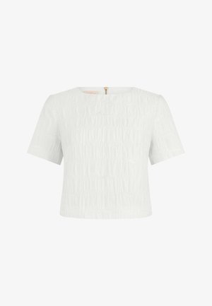 Weiße kurzärmelige Bluse mit Struktur, rundem Halsausschnitt und goldfarbenem Reißverschluss auf der Rückseite, vor schlichtem weißen Hintergrund präsentiert.