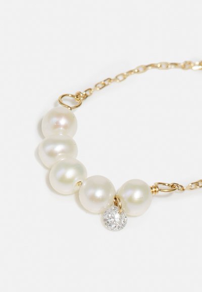Perlový náhrdelník s piatimi hladkými, irizujúco lesklými perlami v krémovej farbe, doplnený okrúhlym zlatým príveskom osadeným čistým kryštálom.