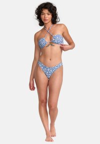 Tweedelige bikiniset met een blauwe bloemenpatroon. Het bovenstuk heeft een keyhole ontwerp met kruislings achterste banden; de broekjes zijn high-waisted.